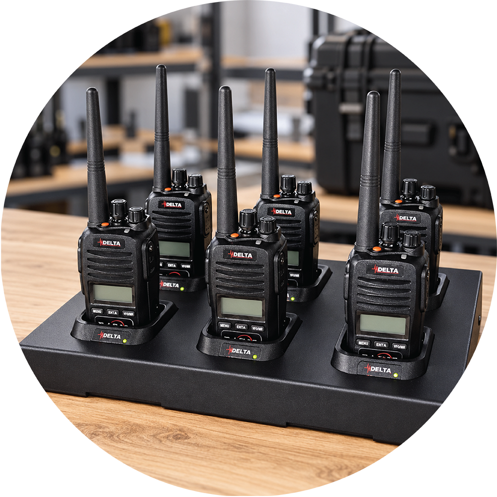 Six Delta AS310 handheld radios seated in a six-bay charger