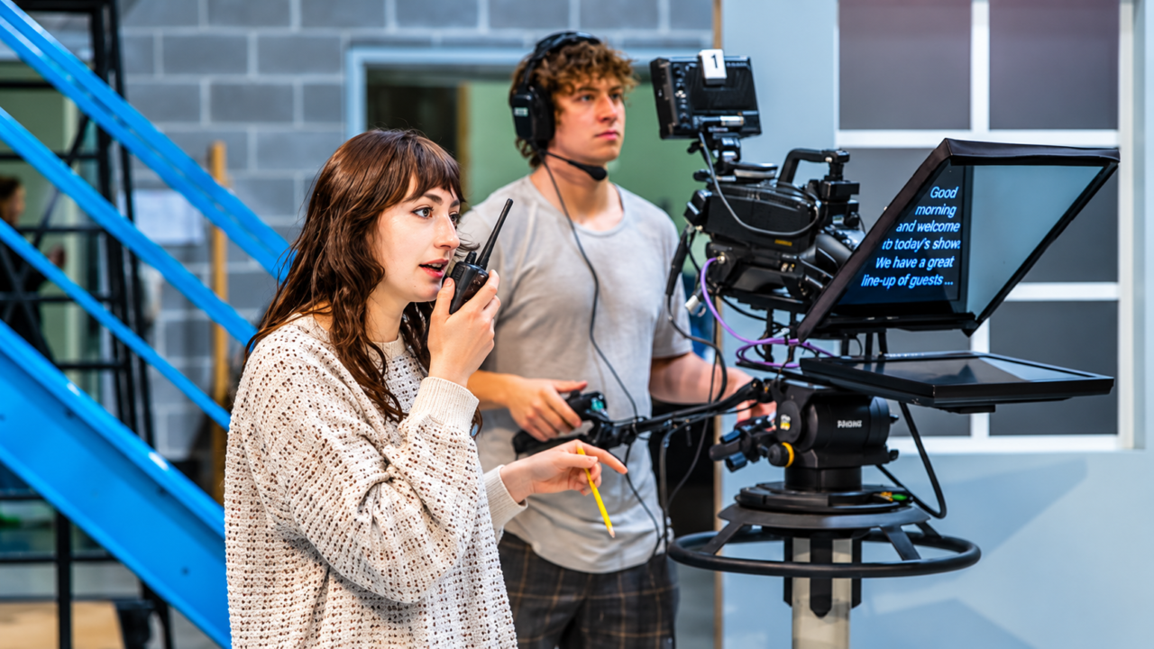 TV production crew using film set two-way radios and a headset in a studio