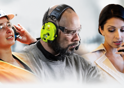 Workers wearing communication headsets and earmuffs