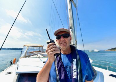 Skipper using a handheld marine radio on a boat