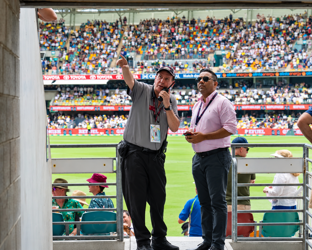 Stadium event coordinator using a stadium two-way radio beside the stands on match day